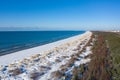 Aerial view of snow covered beach and dunes and blue calm sea Royalty Free Stock Photo