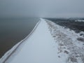 Aerial view of snow covered beach and dunes and dark and calm sea Royalty Free Stock Photo