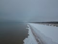 Aerial view of snow covered beach and dunes and dark and calm sea Royalty Free Stock Photo