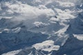 Aerial view of the snow covered Hindu Kush mountain range covered in fluffy white clouds Royalty Free Stock Photo