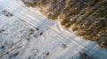 Aerial view of road passing through the snow-covered winter forest. Top view Royalty Free Stock Photo