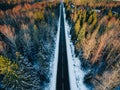 Aerial view of snow covered trees in forest and winter country road with a car Royalty Free Stock Photo