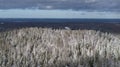 Aerial view of snow-covered Vallamagi hill with forest and Haanja upland in Voru county, Estonia