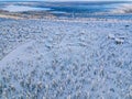Aerial view of snow covered winter forest and road. Beautiful rural landscape in Finland Royalty Free Stock Photo