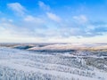 Aerial view of snow covered winter forest and road. Beautiful rural landscape in Finland