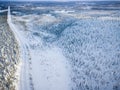 Aerial view of snow covered winter forest and road. Beautiful rural landscape in Finland Royalty Free Stock Photo