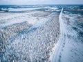 Aerial view of snow covered winter forest and road. Beautiful rural landscape in Finland Royalty Free Stock Photo