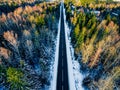 Aerial view of snowy forest with a road. Captured from above with a drone Royalty Free Stock Photo