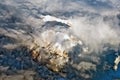 Aerial view of snowy mountains covered by clouds