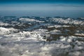 Aerial view of snowy mountains in winter. Flying at sunset above the clouds Royalty Free Stock Photo