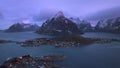 Aerial view of snowy rocks, rorbuer, sea, mountains, purple sky