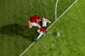 Aerial view of soccer football players in sports uniform and football boots battling for the ball over green grass field Royalty Free Stock Photo