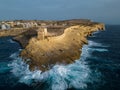 Rough waves against the rock with Xlendi Tower on Gozo island aerial Royalty Free Stock Photo