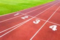 Aerial view of sports stadium with red running tracks with numbers on it and green grass football field Royalty Free Stock Photo