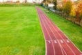 Aerial view of sports stadium with red running tracks with numbers on it and green grass football field Royalty Free Stock Photo