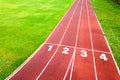 Aerial view of sports stadium with red running tracks with numbers on it and green grass football field Royalty Free Stock Photo