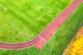 Aerial view of sports stadium with red running tracks with numbers on it and green grass football field Royalty Free Stock Photo