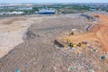 Aerial view of stack of different types of large mountain garbage pile, plastic bags, and trash with a tractor car in industrial Royalty Free Stock Photo