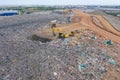 Aerial view of stack of different types of large mountain garbage pile, plastic bags, and trash with a tractor car in industrial Royalty Free Stock Photo