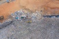 Aerial view of stack of different types of large mountain garbage pile, plastic bags, and trash with a tractor car in industrial Royalty Free Stock Photo
