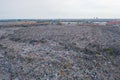 Aerial view of stack of different types of large mountain garbage pile, plastic bags, and trash with a tractor car in industrial Royalty Free Stock Photo