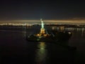 Aerial view of the Statue of Liberty at night with the lights of New Jersey in the background Royalty Free Stock Photo