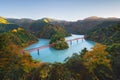 Aerial view of the steam train crossing Oigawa Railroad to go to station with red fall foliage in forest mountain hills and blue Royalty Free Stock Photo