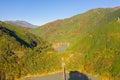 Aerial view of the steam train crossing Oigawa Railroad to go to station with red fall foliage in forest mountain hills and blue Royalty Free Stock Photo