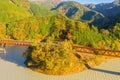 Aerial view of the steam train crossing Oigawa Railroad to go to station with red fall foliage in forest mountain hills and blue Royalty Free Stock Photo