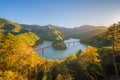 Aerial view of the steam train crossing Oigawa Railroad to go to station with red fall foliage in forest mountain hills and blue Royalty Free Stock Photo