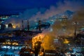 Aerial view of steel plant at night with smokestacks and fire blazing out of the pipe. Industrial panoramic landmark Royalty Free Stock Photo