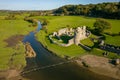 Aerial view of stepping stones over a small river leading to the ruins of an ancient castle Ogmore Castle, Wales Royalty Free Stock Photo