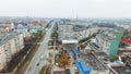 Aerial view of a street with multi-storey prefabricated houses, a church and a highway.