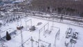 Aerial view of substation of high-voltage power line. Action. Winter landscape with industrial zone near forest and Royalty Free Stock Photo