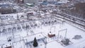 Aerial view of substation of high-voltage power line. Action. Winter landscape with industrial zone near forest and Royalty Free Stock Photo