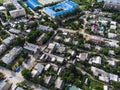 Aerial view of suburb of European city. Green neighbourhood on a sunny summer day. County living. Drone point of view