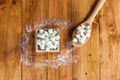 Aerial View of Sugar Cubes in Square Shaped Bowl and Spoon with Unrefined Sugar spill over in Wooden Background. Royalty Free Stock Photo