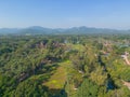 Aerial view of Sukhothai Historical Park, buddha pagoda stupa in a temple, Sukhothai, Thailand with green mountain hills and