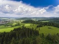 Aerial view of the summer time in mountains near Stronie Slaskie town in Poland. Pine tree forest and clouds over blue sky. View Royalty Free Stock Photo