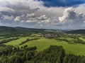 Aerial view of the summer time in mountains near Stronie Slaskie town in Poland. Pine tree forest and clouds over blue sky. View Royalty Free Stock Photo