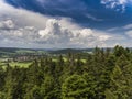 Aerial view of the summer time in mountains near Stronie Slaskie town in Poland. Pine tree forest and clouds over blue sky. View Royalty Free Stock Photo