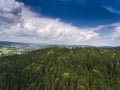 Aerial view of the summer time in mountains near Stronie Slaskie town in Poland. Pine tree forest and clouds over blue sky. View Royalty Free Stock Photo