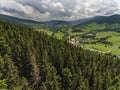 Aerial view of the summer time in mountains near Stronie Slaskie town in Poland. Pine tree forest and clouds over blue sky. View Royalty Free Stock Photo