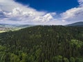 Aerial view of the summer time in mountains near Stronie Slaskie town in Poland. Pine tree forest and clouds over blue sky. View Royalty Free Stock Photo