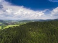 Aerial view of the summer time in mountains near Stronie Slaskie town in Poland. Pine tree forest and clouds over blue sky. View Royalty Free Stock Photo