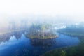 An aerial view of foggy morning in Mukri bog in Estonia with some small bog lakes and islands in Northern Europe.