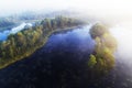 An aerial view of foggy morning in Mukri bog in Estonia with some small bog lakes and islands in Northern Europe.