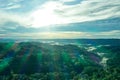 Aerial view of the sun coming through the clouds after a rainy day in a tropical rianforest with some clouds covering the tree Royalty Free Stock Photo