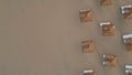 Aerial view sun loungers and straw parasols on seashore. No people morning beach Royalty Free Stock Photo