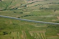 Aerial view of sunlit fields with a highway in the middle Royalty Free Stock Photo